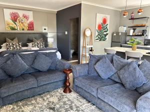 a living room with a couch and a bed at Tree Aloe Guest house in St Francis Bay