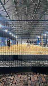 un gruppo di persone che giocano a baseball in una gabbia di Hotel Pousada Flat Royal Suíte Stander 2 camas box a Itapecerica