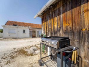 a barbecue grill sitting next to a building at Maison rénovée à Mimizan pour 10 pers. avec jardin proche océan - FR-1-50-194 in Mimizan