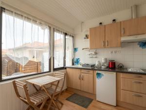 eine Küche mit Holzschränken, einem Tisch und einem Fenster in der Unterkunft Appartement pour 3 à Mimizan Plage, à 50m de l'océan avec terrasse et parking, ménage inclus - FR-1-50-123 in Mimizan + 3 Fotos