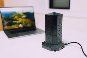 Un pequeño dispositivo electrónico sobre una mesa con una computadora portátil. en Showa Bloom Shinjuku 3, en Tokio