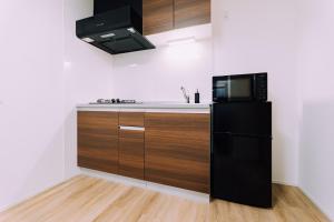 cocina con nevera negra y microondas en Showa Bloom Shinjuku 3, en Tokio