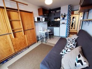a living room with a couch and a kitchen at Studio rénové, balcon vue vallée, proche centre et remontées - FR-1-771-1 in Les Adrets