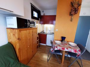 Les AdretsStudio confortable pied des pistes, animaux interdits - FR-1-771-6的带桌子和微波炉的小厨房