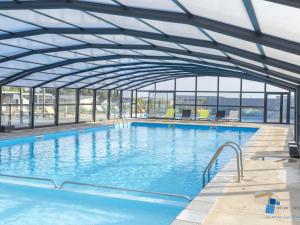 a large swimming pool with a retractable roof at Chalet 3 chb, 2 sde, domaine sécurisé avec piscine chauffée, proche plages Méditerranée - FR-1-783-22 in Pomérols +21 photos