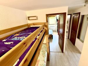- une chambre avec des lits superposés en bois dans l'établissement Appartement avec terrasse, 1 chambre, 6 pers, Wi-Fi et Parking privé - FR-1-836-55, aux Carroz d'Arâches