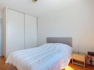 - une chambre avec un grand lit blanc et une table de nuit dans l'établissement Appartement T3 avec Climatisation et Parking à Soustons - FR-1-857-19, à Soustons