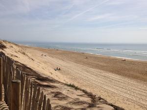 une plage avec des gens assis sur le sable dans l'établissement Appartement T3 avec Climatisation et Parking à Soustons - FR-1-857-19, à Soustons 3 autres photos