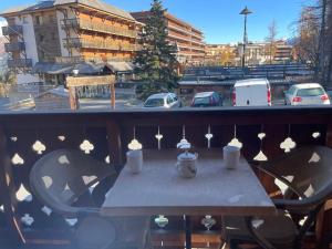 普华露Appartement familial à Pra-Loup 1600 proche des pistes - FR-1-165A-209的阳台的桌子,享有停车场的景色 更多3张照片