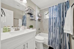 a bathroom with a sink and a toilet and a tub at Elegant 4BD Near NRG stadium, Downtown in Houston +20 photos