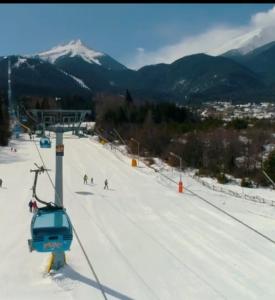 einen Skilift mit Leuten, die auf einer schneebedeckten Piste Ski fahren in der Unterkunft Ski view suite Emerald Bansko in Bansko