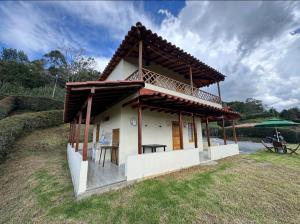 a small house with a balcony and a table at Finca la Esperanza in Guarne