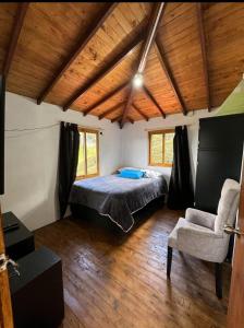 a bedroom with a bed and a chair in a room at Finca la Esperanza in Guarne