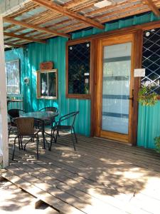 Un patio con una mesa y sillas en una terraza. en Cabañas las Palmeras de Colbun, en Linares