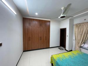 a bedroom with a bed and a wooden cabinet at Ranim Family Lodge Abbottabad in Abbottābād