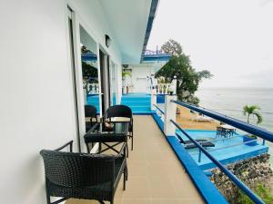 a balcony with chairs and a view of the ocean at Campbells Beach Resort in Puerto Galera