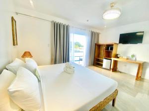 a living room with a white couch and a television at Campbells Beach Resort in Puerto Galera