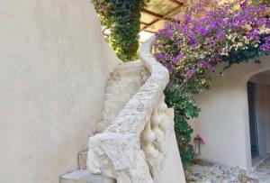 a stone staircase with flowers on the side of a building at Eryvazur in Vallauris