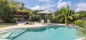 a large swimming pool in a yard with trees at Eryvazur in Vallauris