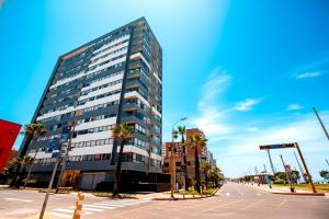 a tall building with palm trees in front of a street at Perfect Balance Rest and Work Study Oceanfront in San Antonio