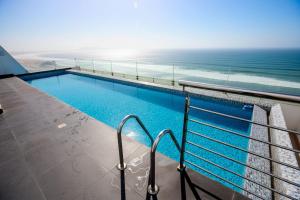 a swimming pool with the ocean in the background at Perfect Balance Rest and Work Study Oceanfront in San Antonio
