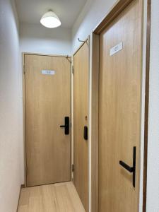 un par de puertas de madera en un pasillo en Ippaku 一泊, en Izumisano