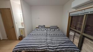 Un dormitorio con una cama con una manta encima. en Ippaku 一泊, en Izumisano 36 fotos más