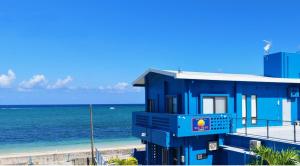 a blue building on the beach next to the ocean at SEA BASE Onna in Onna