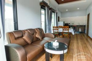 un salon avec un canapé marron et une table dans l'établissement Arterra Haven Aonang Krabi, à Ban Chong Phli
