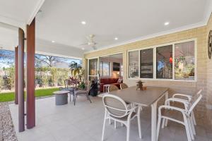 eine Terrasse mit einem Tisch, Stühlen und einem Sofa in der Unterkunft The Wren's Nest in Sandstone Point