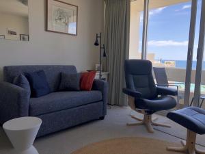 a living room with a couch and a chair at Beachside Paradise - Ocean Views, Central Position in Sydney