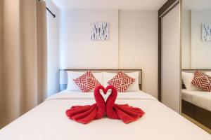 a bed with a red bow in the shape of a heart at 芭提雅市中心度假公寓 The Base预定 免费游泳池健身房 生活购物便利 in Pattaya Central +12 photos