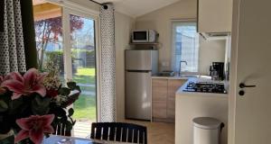 a kitchen with a refrigerator and a counter top at ZEcamping 3 étoiles animaux acceptés à proximité des plus beaux sites in Pordic