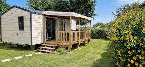 a tiny house with a porch in a yard at ZEcamping 3 étoiles animaux acceptés à proximité des plus beaux sites in Pordic