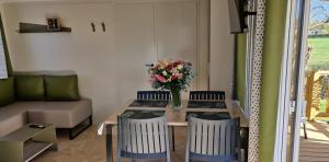 a living room with a table with a vase of flowers at ZEcamping 3 étoiles animaux acceptés à proximité des plus beaux sites in Pordic +34 photos