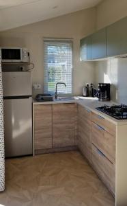 a kitchen with a sink and a refrigerator at ZEcamping 3 étoiles animaux acceptés à proximité des plus beaux sites in Pordic