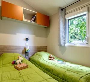 Deux lits dans une chambre avec deux ours en peluche dans l'établissement Camping 3 étoiles - ccbc0hb, à Pordic