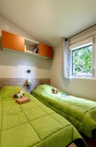 deux lits dans une chambre avec des draps verts dans l'établissement Camping 3 étoiles - ccbc0hb, à Pordic