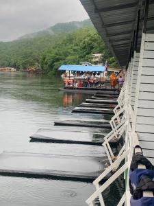 un pont sur une rivière avec un bateau dans l'eau dans l'établissement River View Resort ริเวอร์ วิว รีสอร์ท, à Tha Kradan