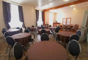 une pièce vide avec des tables, des chaises et des fenêtres dans l'établissement Aubergeducouvent, à Saint-Casimir
