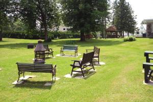 un groupe de bancs de parc assis dans l'herbe dans l'établissement Aubergeducouvent, à Saint-Casimir 2 autres photos