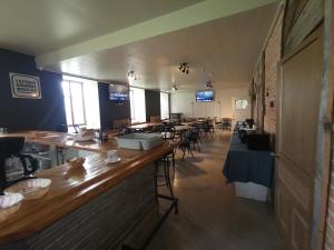 a bar in a restaurant with tables and chairs at Auberge du Couvent in Saint-Casimir
