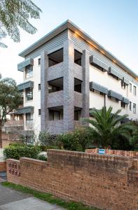 ein Apartmenthaus mit einer Backsteinmauer davor in der Unterkunft Bright Studio Steps from Westmead Hospital in Sydney