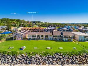 Absolute Beachfront Apartments 3T في لينوكس هيد: اطلاله هوائيه على منزل مع ساحه كبيره