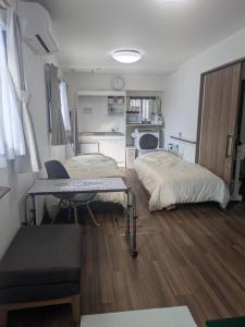 Barrier Free Guesthouse Support Included في أوساكا: غرفة بسريرين وطاولة ومطبخ