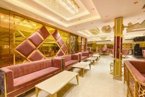 a waiting room with pink couches and tables at Hotel Rock View in New Delhi