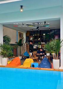 una piscina con colchonetas de colores en una habitación con plantas en THE PLACE Hostel Siem Reap Angkor, en Siem Reap