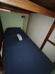 a bed in a small room with a blue sheet at Corner Crib El Nido Hostel in El Nido +8 photos