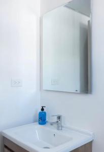 une salle de bains avec un lavabo blanc et un miroir dans l'établissement BOvibe Condo - 2 Suites avec Piscine - Pueblo Bávaro, à Punta Cana