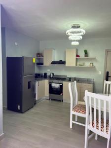 une cuisine avec deux chaises blanches, une table et des appareils électroménagers dans l'établissement BOvibe Condo - 2 Suites avec Piscine - Pueblo Bávaro, à Punta Cana